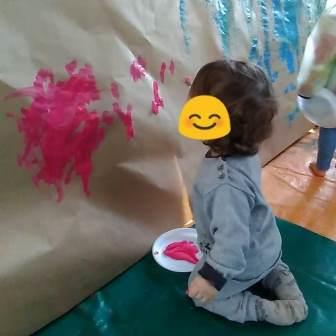 enfants à genoux qui peind sur du papier craft